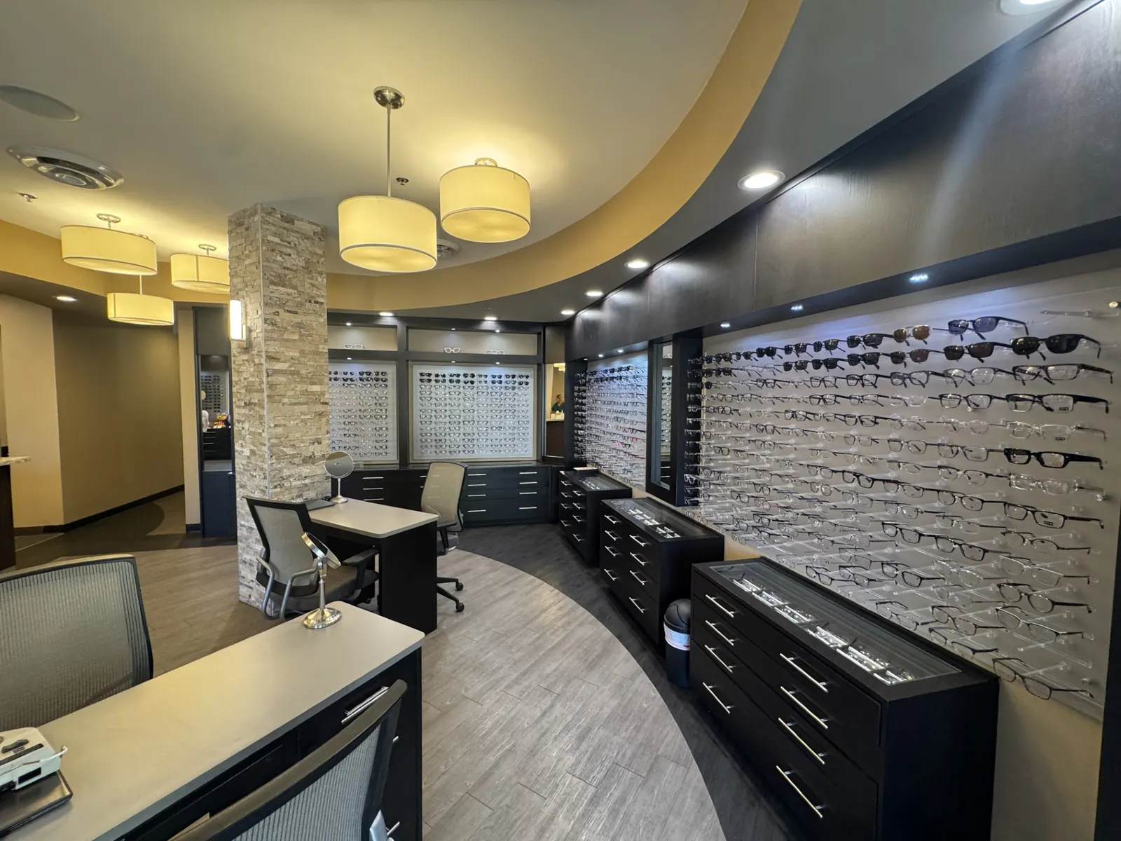 The Tatum Eyecare optical showroom with illuminated displays containing hundreds of eyeglass frames and individual fitting tables